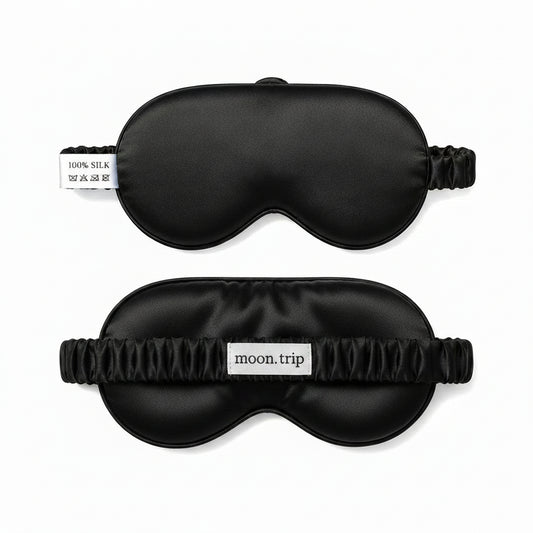 Two blue silk sleep masks with 'moon trip' branding on a white background