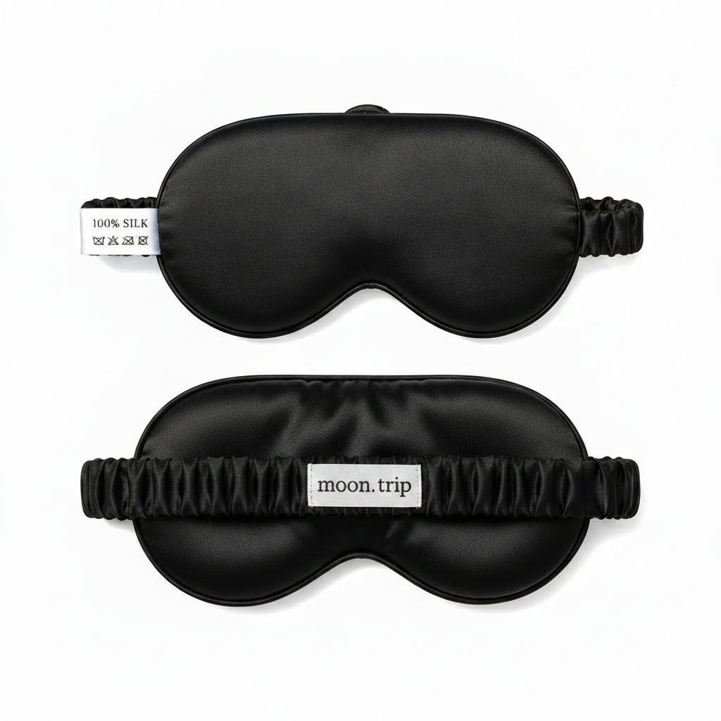 Two blue silk sleep masks with 'moon trip' branding on a white background